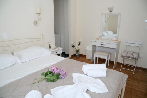 a bedroom with a bed with towels and flowers on it at Terpsichore Boutique Appartments in Dassia