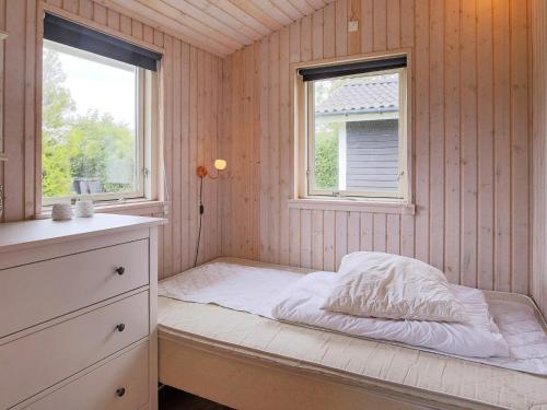 a small bedroom with a bed and two windows at 6 person holiday home in Slagelse in Slagelse