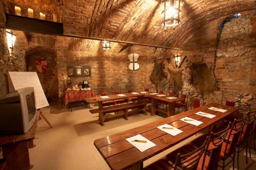 restauracja z drewnianymi stołami i krzesłami w pokoju w obiekcie Globtroter Guest House w Krakowie