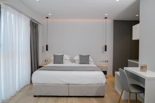 a bedroom with a large bed and a desk at The Convo Syngrou Apartments in Athens
