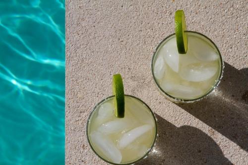 two pictures of a drink with a green straw in it at The Diplomat Boutique Hotel in Mérida
