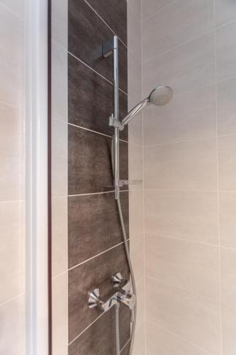 une douche avec une porte vitrée dans une salle de bain dans l'établissement Cocon, vue Rodez, terrasse, box, musée Soulages, à Rodez