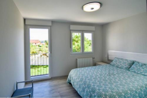 a bedroom with a bed and two windows at ¡Nuevo! Casa reformada, cómoda y con vistas al mar in Santander