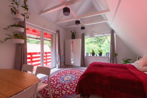 sypialnia z czerwonym łóżkiem, stołem i krzesłami w obiekcie Zawoja 1725 - Slow Life Cabins w Zawoi