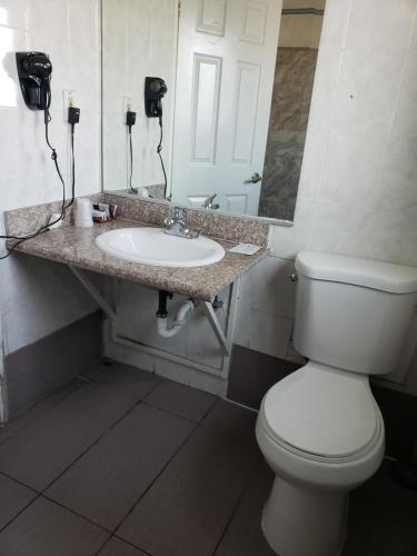 een badkamer met een wit toilet en een wastafel bij Eagle Inn Motel in Long Beach