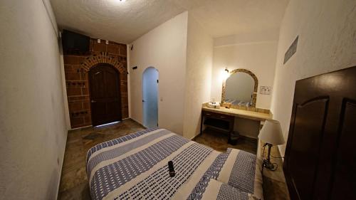 a bedroom with a bed and a sink and a mirror at La Buena Suerte in Tepoztlán