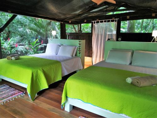 A bed or beds in a room at Four Monkeys Eco Lodge - Jungle & Beach