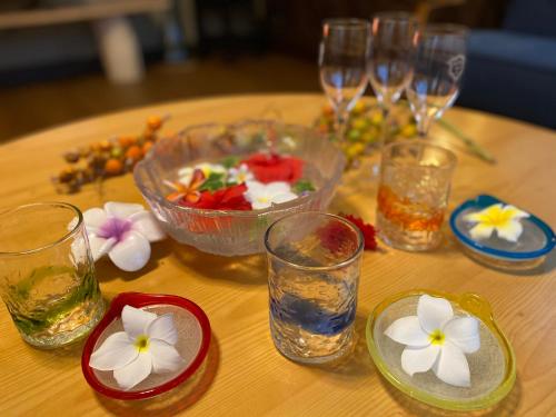 une table avec des verres et des bols de nourriture et de fleurs dans l'établissement Irodoru, à Ishigaki