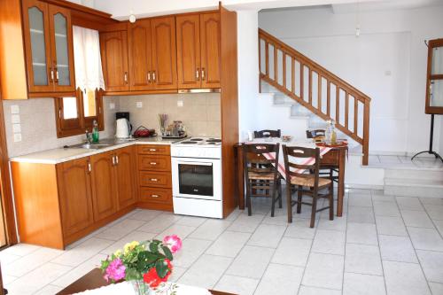 a kitchen with wooden cabinets and a table with chairs at Matina - Stavros Traditional Houses in Kóronos