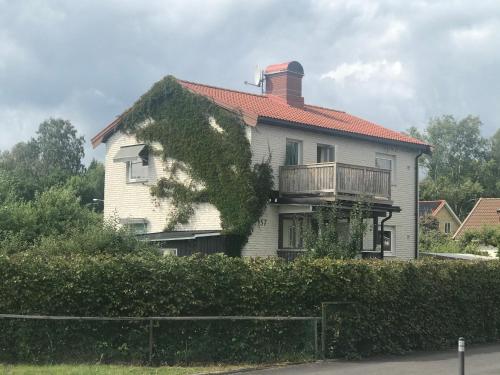 a white house with a balcony on top of it at 2 rum och kök på Färjestad in Karlstad
