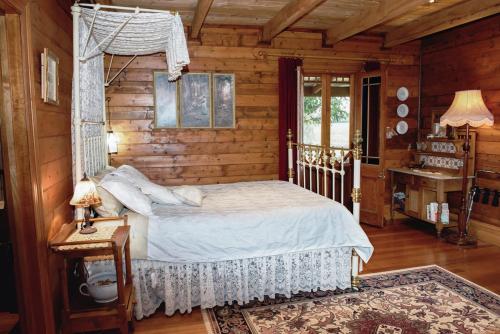 Un dormitorio con una cama en una cabaña de troncos en Colby Cottages, Wooragee near Beechworth, en Wooragee