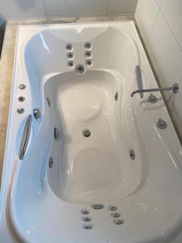 a white bath tub with tongs in a bathroom at Southern Comfort Motel in Christchurch