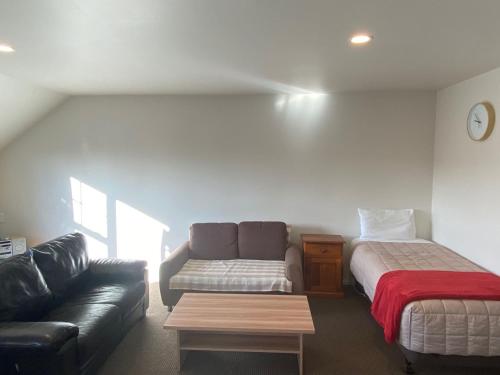 a living room with a couch and a bed at Southern Comfort Motel in Christchurch