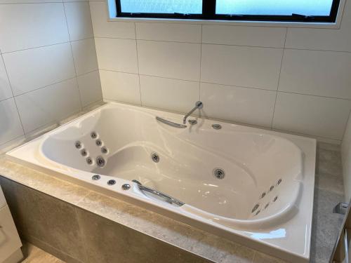 a white bath tub in a bathroom with a window at Southern Comfort Motel in Christchurch