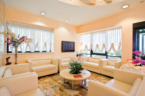a large waiting room with white furniture and windows at Hotel Ida in Rimini