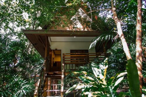 une maison au milieu d'une forêt plantée d'arbres dans l'établissement The Vatika Resort and Spa, à Ao Nang Beach