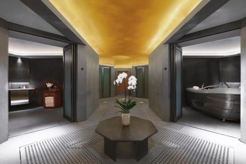 ein Badezimmer mit einer Badewanne und einer Vase mit Blumen auf einem Tisch in der Unterkunft Chiva-Som International Health Resorts in Hua Hin