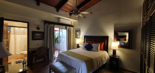 - une chambre avec un lit et un ventilateur de plafond dans l'établissement Humuya Inn, à Tegucigalpa