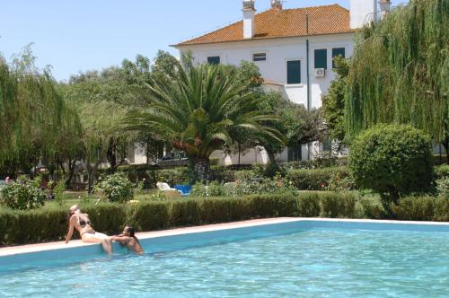 two people are sitting in a swimming pool at Elxadai Parque in Elvas