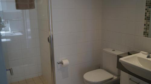 a bathroom with a toilet and a shower and a sink at Canberra CBD Metropolitan in Canberra