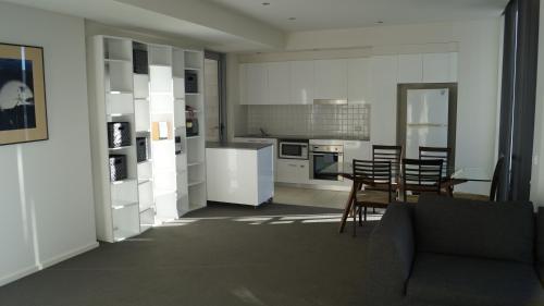 a kitchen and living room with a couch and a table at Canberra CBD Metropolitan in Canberra
