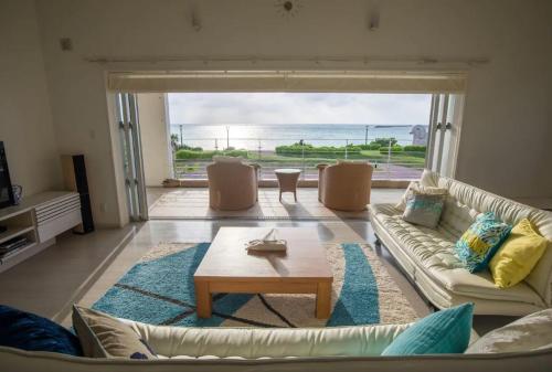 a living room with a couch and a coffee table at Ocean view Shiozaki in Maezato