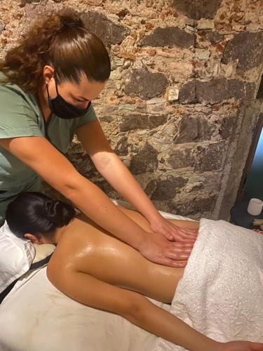 a woman is sitting on a bed with her foot on her back at Hotel Spa Casa del Sol in Guanajuato