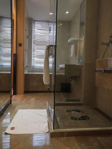a bathroom with a shower with a glass door at Ramada Plaza Qiandeng Kunshan in Kunshan
