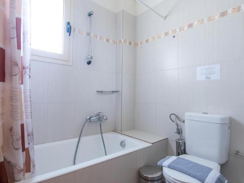 a bathroom with a tub and a toilet and a shower at Manoleas Villas - Apartment 3 in Stoupa