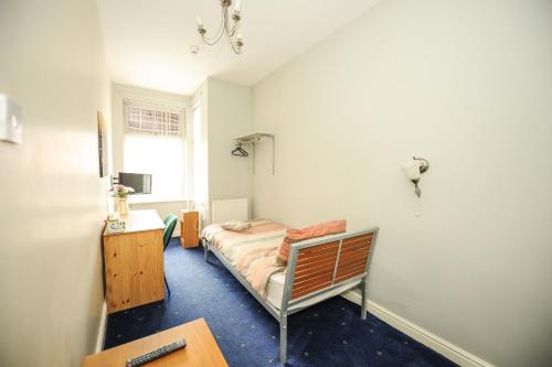 a bedroom with a bed and a desk and a window at Maryland in Derby