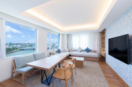uma sala de estar com uma mesa e uma grande janela em Tokyu Stay Okinawa Naha em Naha