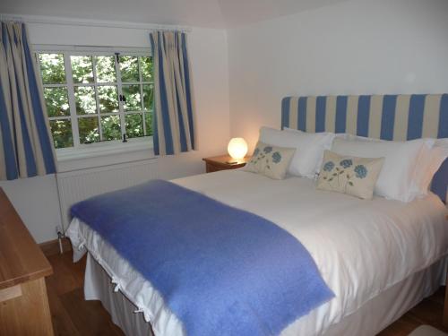 a bedroom with a bed with a blue blanket on it at The Apartment at Hillside Lodge in Broadway