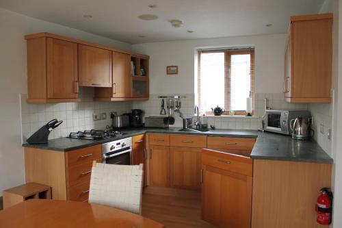 a kitchen with wooden cabinets and a stove top oven at Moss Tarn in Ulverston