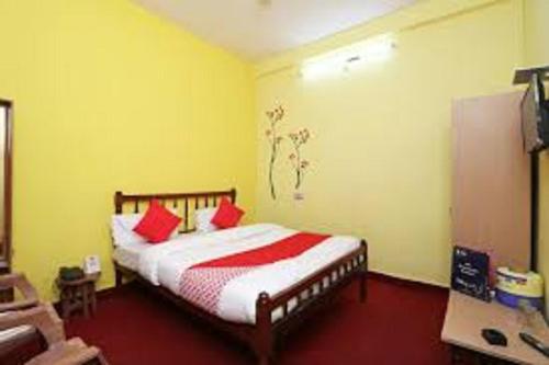 um quarto com uma cama com almofadas vermelhas em Priyanshu Lodge em Kharsālī