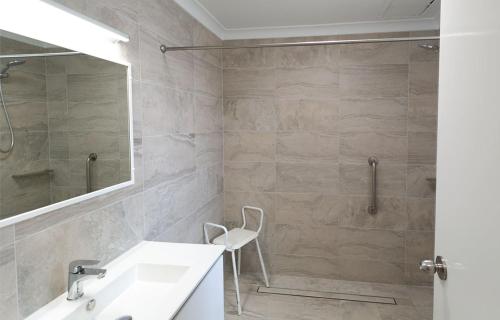 a bathroom with a shower and a sink and a mirror at Esplanade Hotel Busselton in Busselton