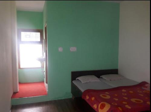 1 dormitorio con 1 cama en una habitación con ventana en Hotel Utsav Palace en Uttarkāshi