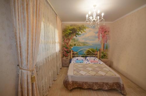 ゲレンジークにあるHouse in Gelendzhik centreの壁に絵画が描かれたベッドルーム、ベッド1台が備わります。