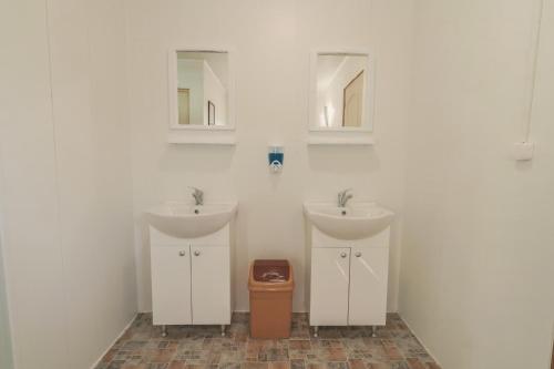 uma casa de banho com dois lavatórios e uma lata de lixo em NirVama Tent Glamping em Vama Veche