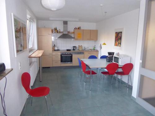 una cocina con mesa y sillas rojas. en Comfort Apartment, en Tübingen