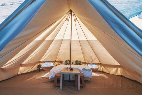 a tent with a table in the middle at NirVama Tent Glamping in Vama Veche