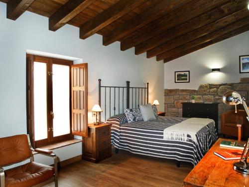 a bedroom with a bed and a chair in a room at La Casa del Vino in Fermoselle