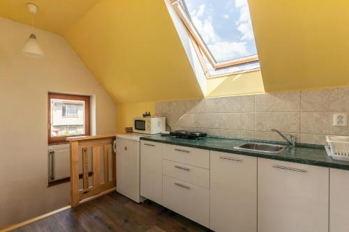 eine Küche mit einem Waschbecken und einem Dachfenster in der Unterkunft VS apartmán in Turnov