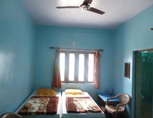 a bedroom with two beds and a ceiling fan at Hotel SHREE Uttarkashi in Uttarkāshi