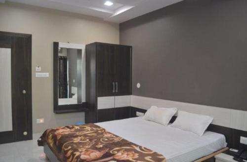 a bedroom with a bed and a mirror in it at Premium hotel near Nagoa Beach in Diu