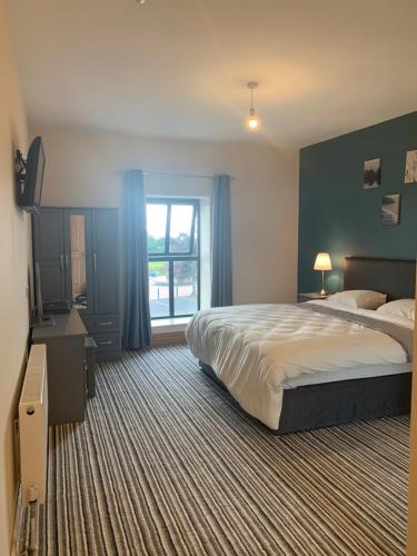a hotel room with a bed and a window at The Local Lodge in Longford