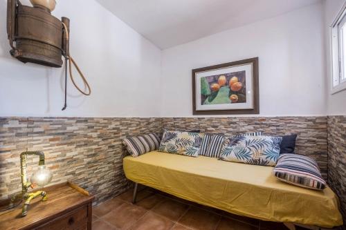 ein Sofa in einem Zimmer mit Ziegelwand in der Unterkunft Casa Cardón - Villa Perenquén in Guía de Isora