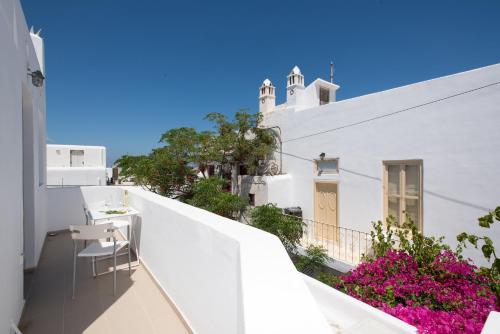 - Balcón con mesa y sillas en un edificio blanco en Lirous Studios, en Mykonos ciudad