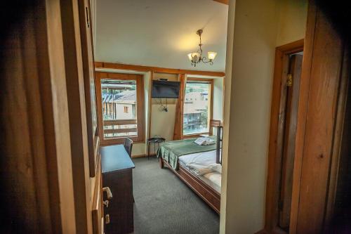 a small room with a bed and a window at Hotel Old Seti in Mestia