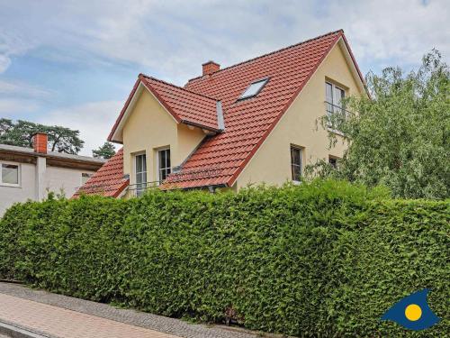 ein Haus mit rotem Dach auf einer Hecke in der Unterkunft Kirchstr 4a in Bansin