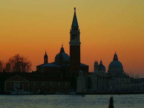 a large building with a clock tower at sunset at Porta da mar in Venice